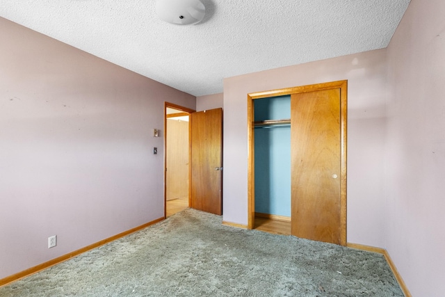 unfurnished bedroom featuring a textured ceiling, carpet floors, and a closet