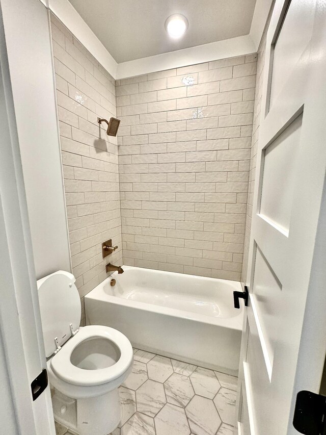 bathroom featuring toilet and tiled shower / bath