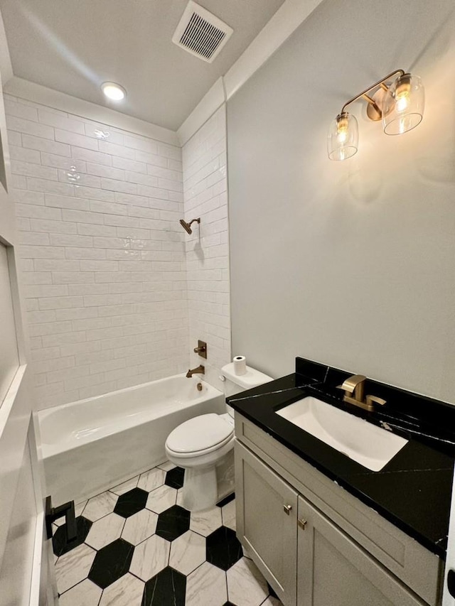 full bathroom featuring toilet, vanity, tile patterned floors, and tiled shower / bath combo