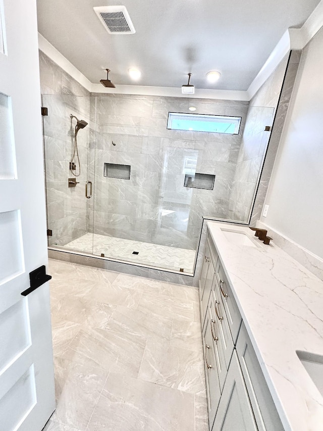 bathroom featuring a shower with door and vanity