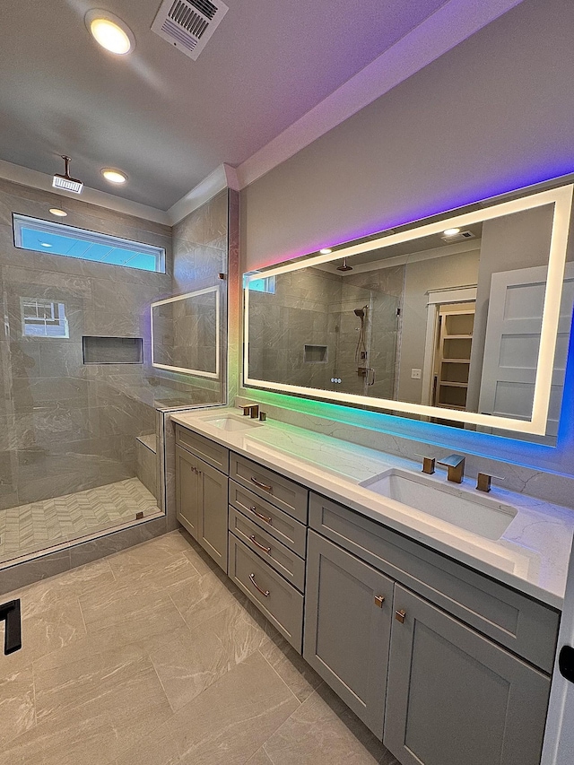 bathroom featuring a shower with door and vanity