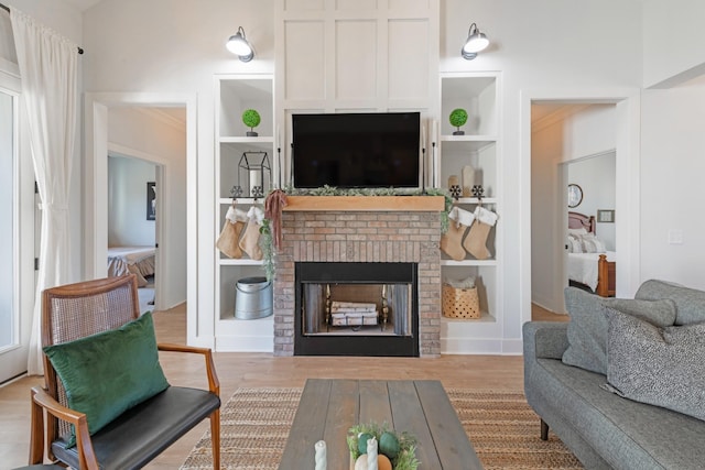 living room featuring light hardwood / wood-style floors, built in features, and a fireplace