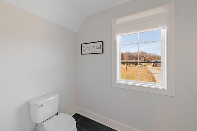 bathroom with tile patterned floors, lofted ceiling, and toilet