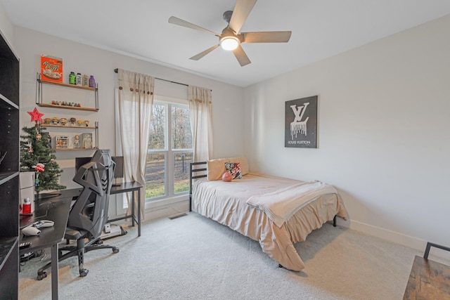 carpeted bedroom featuring multiple windows and ceiling fan