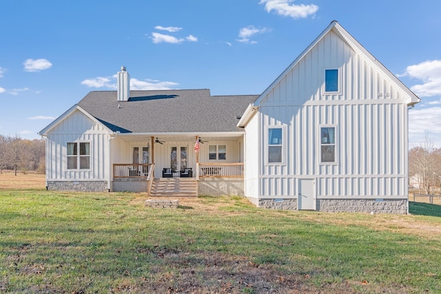 rear view of property featuring ceiling fan, a yard, and a porch