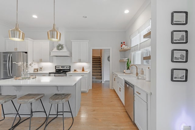 kitchen featuring sink, stainless steel appliances, light hardwood / wood-style flooring, crown molding, and white cabinets