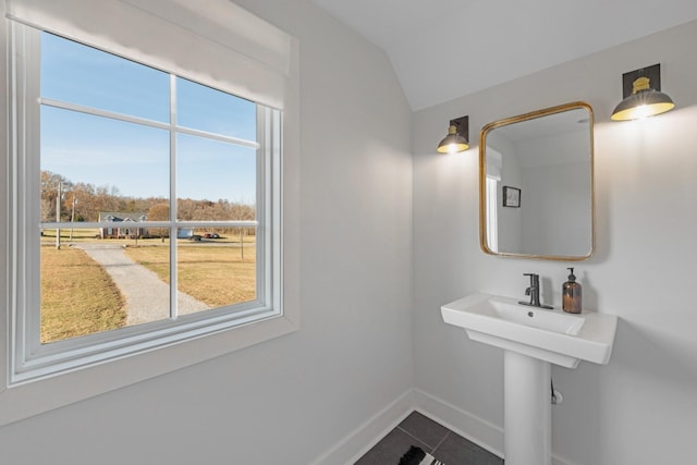 bathroom featuring lofted ceiling, tile patterned floors, and a healthy amount of sunlight