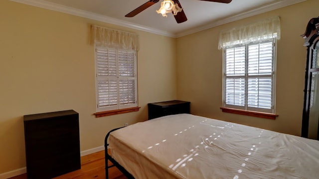 bedroom with ceiling fan, wood-type flooring, and ornamental molding