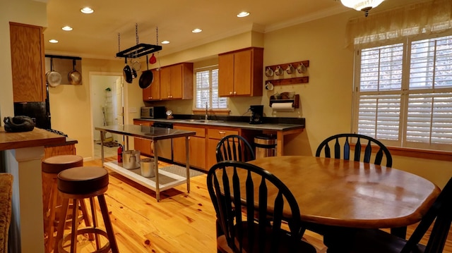 kitchen with dishwasher, light hardwood / wood-style flooring, plenty of natural light, and crown molding