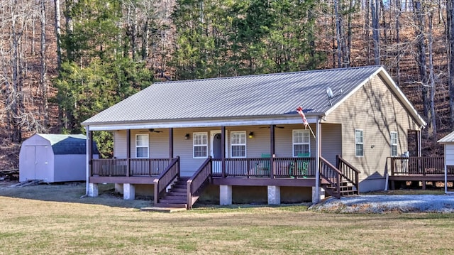 view of front of property with covered porch, a shed, and a front yard