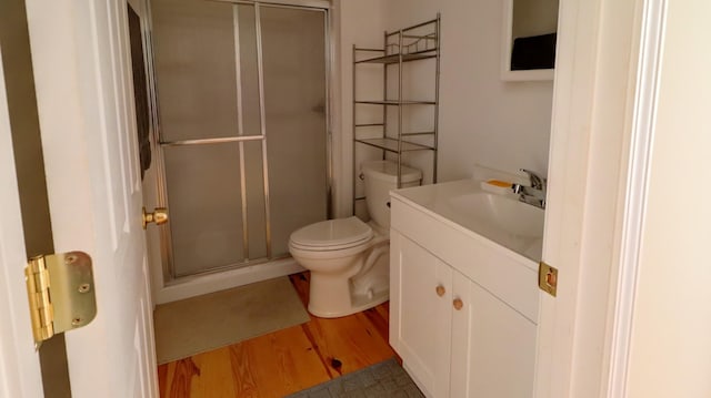 bathroom with vanity, toilet, wood-type flooring, and walk in shower