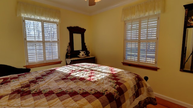 bedroom featuring hardwood / wood-style floors, ceiling fan, and ornamental molding