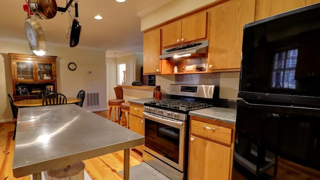 kitchen with stainless steel gas range oven, light hardwood / wood-style flooring, and ornamental molding