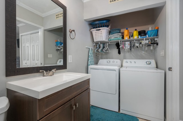 clothes washing area with sink, separate washer and dryer, and crown molding