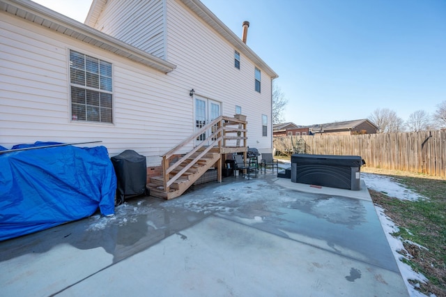 rear view of house with a patio area and a hot tub