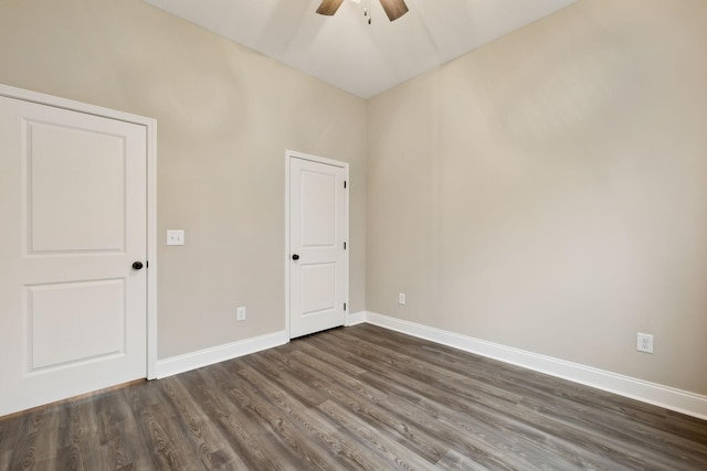 empty room with dark hardwood / wood-style floors and ceiling fan