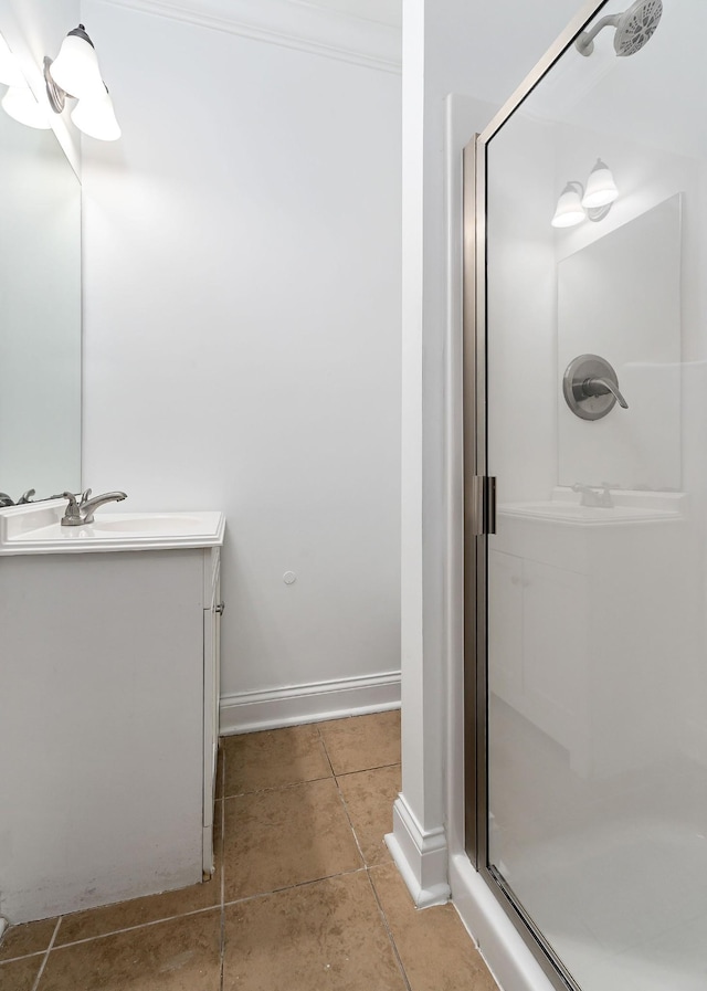 bathroom with tile patterned floors, vanity, ornamental molding, and walk in shower