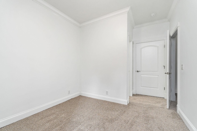 carpeted spare room featuring crown molding