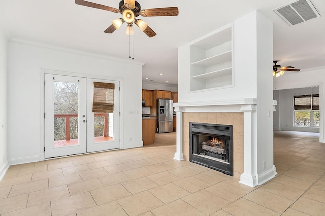 unfurnished living room featuring ceiling fan, light tile patterned floors, crown molding, and a wealth of natural light