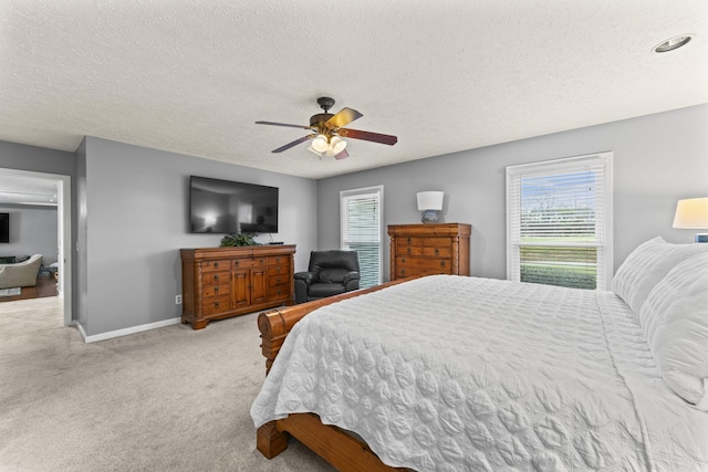 carpeted bedroom featuring ceiling fan and a textured ceiling