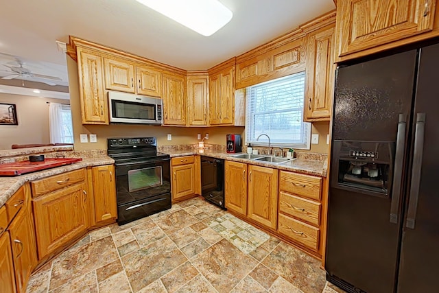 kitchen featuring sink, light stone counters, ceiling fan, and black appliances