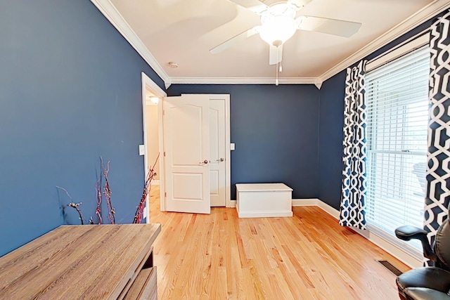 unfurnished room with ceiling fan, light wood-type flooring, and crown molding