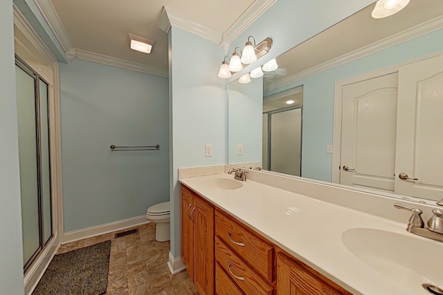 bathroom featuring vanity, toilet, a shower with door, and crown molding