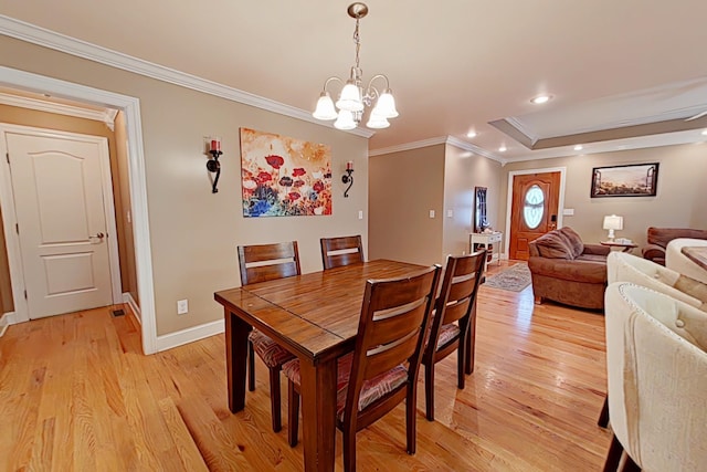 dining space with a chandelier, light wood-type flooring, and ornamental molding