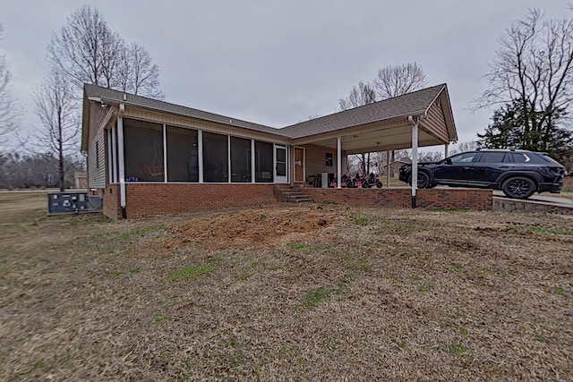 back of house featuring a carport and a sunroom