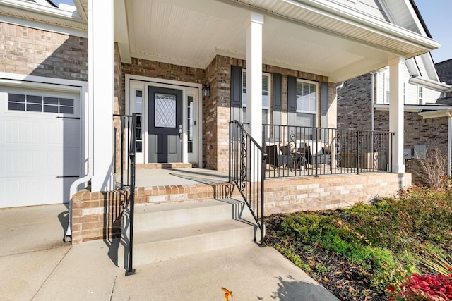 view of exterior entry with a porch and a garage