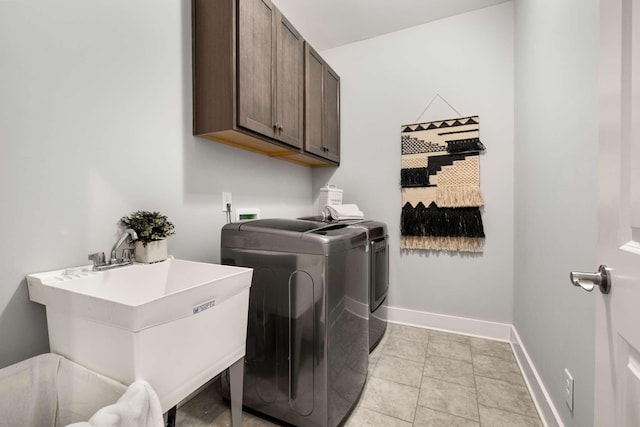 washroom featuring cabinets, light tile patterned flooring, washing machine and dryer, and sink