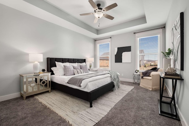 bedroom with carpet, a tray ceiling, and ceiling fan