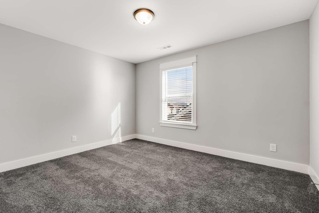 spare room with dark colored carpet