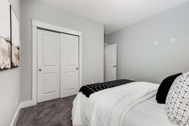 bedroom with dark colored carpet and a closet