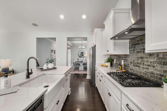 kitchen featuring dark wood-type flooring, stainless steel appliances, light stone counters, and wall chimney exhaust hood