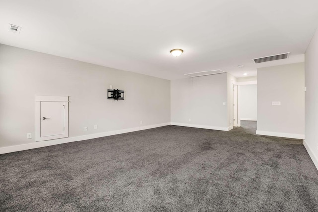 spare room featuring dark colored carpet