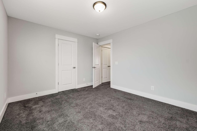 unfurnished bedroom with dark carpet