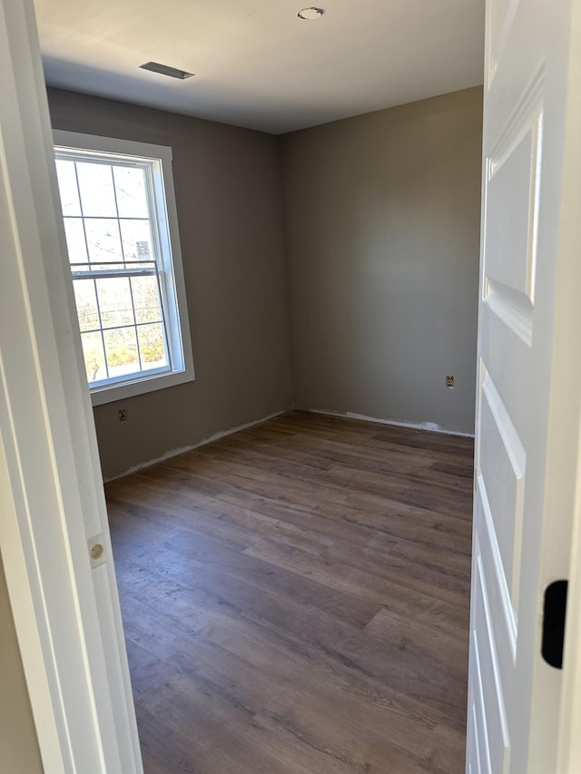 empty room with dark wood-type flooring