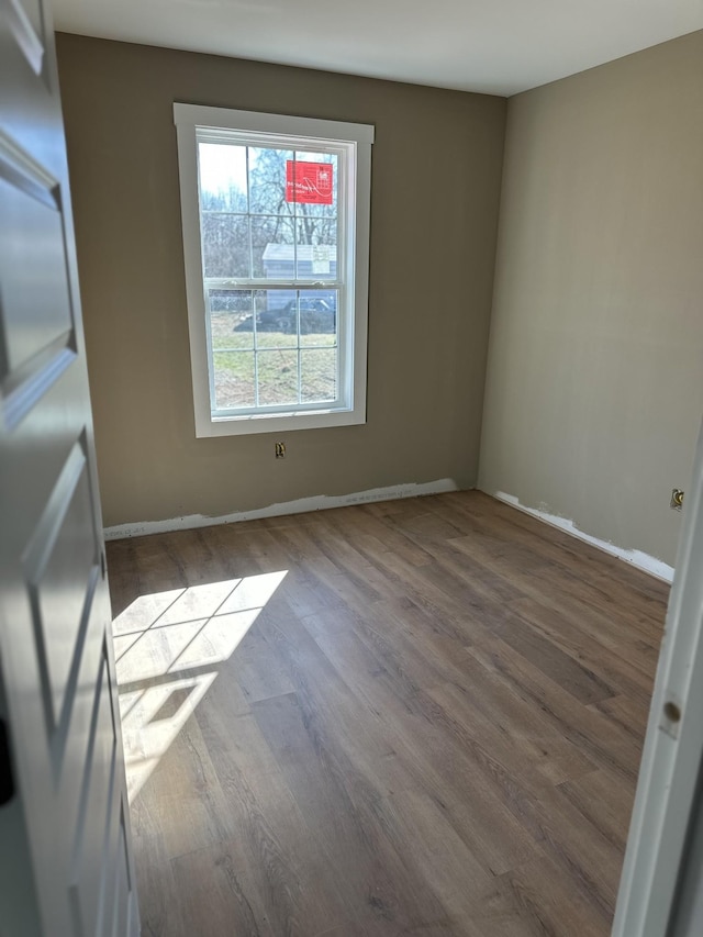 empty room featuring wood finished floors and baseboards