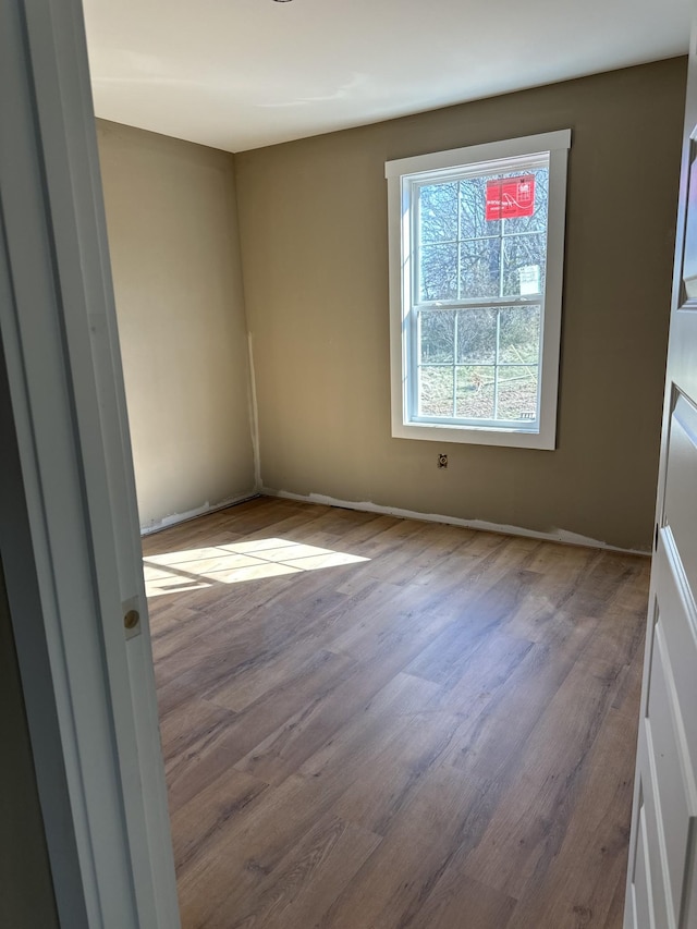 empty room featuring baseboards and wood finished floors