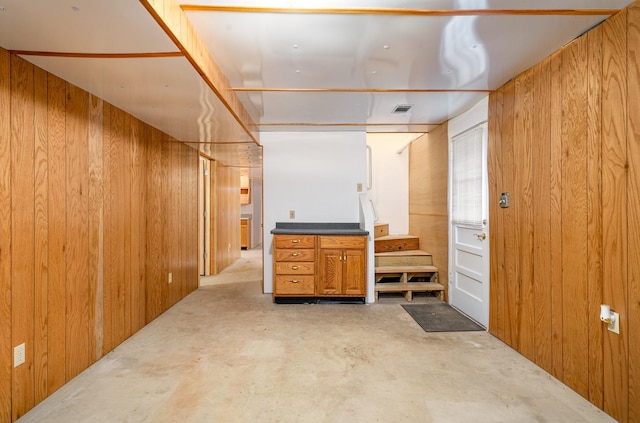 bathroom with wooden walls and concrete floors