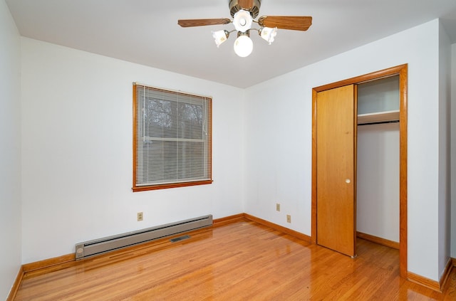 unfurnished bedroom featuring ceiling fan, light hardwood / wood-style floors, a closet, and a baseboard radiator