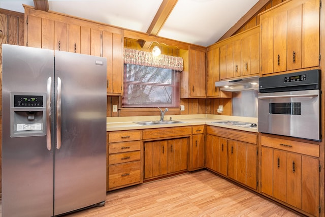 kitchen with sink, light wood-type flooring, vaulted ceiling, and appliances with stainless steel finishes