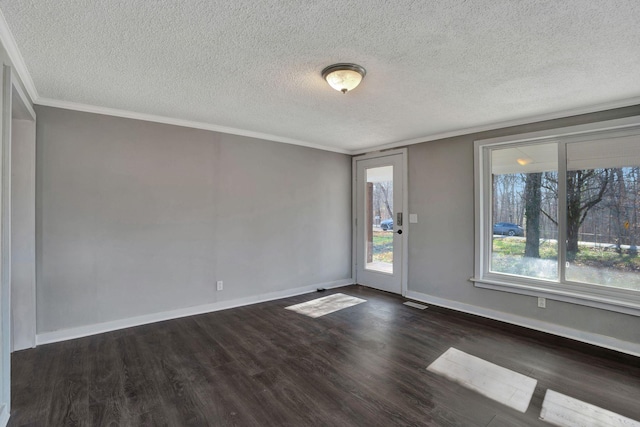 empty room featuring dark hardwood / wood-style flooring, ornamental molding, and a textured ceiling