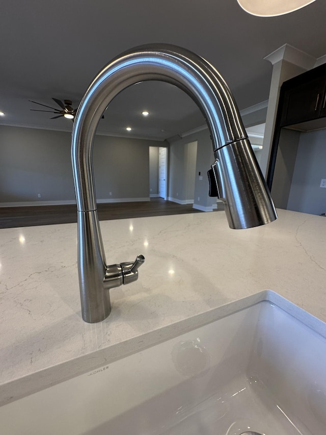 interior details with light stone countertops, ceiling fan, crown molding, and sink