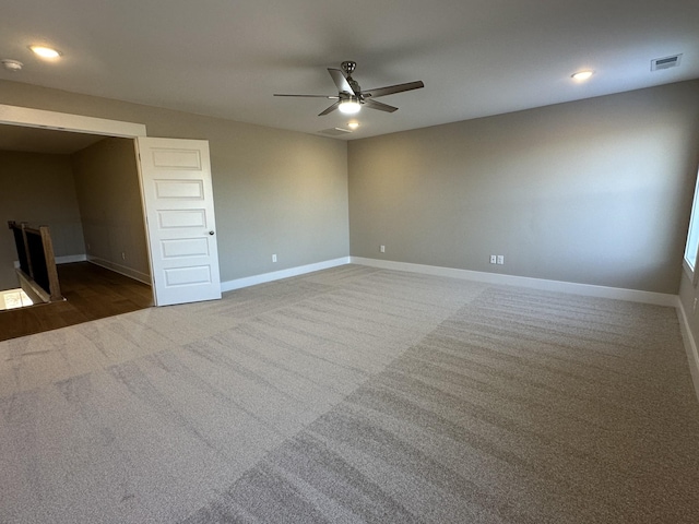 carpeted spare room featuring ceiling fan