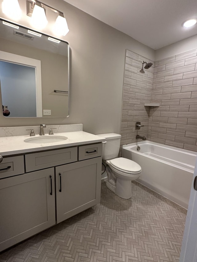 full bathroom with toilet, vanity, and tiled shower / bath