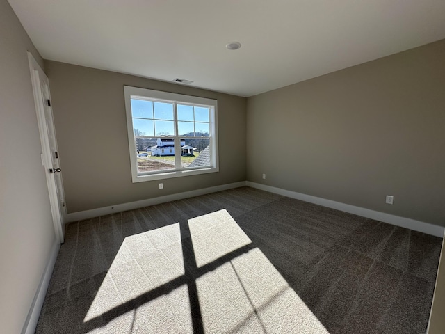 empty room with dark colored carpet