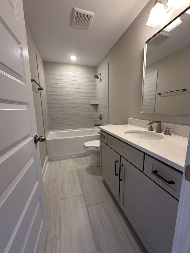 full bathroom featuring toilet, vanity, and tiled shower / bath combo