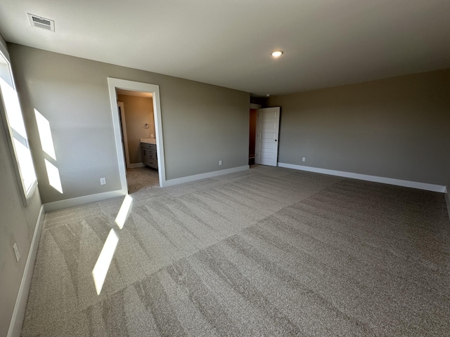 interior space featuring light colored carpet and connected bathroom